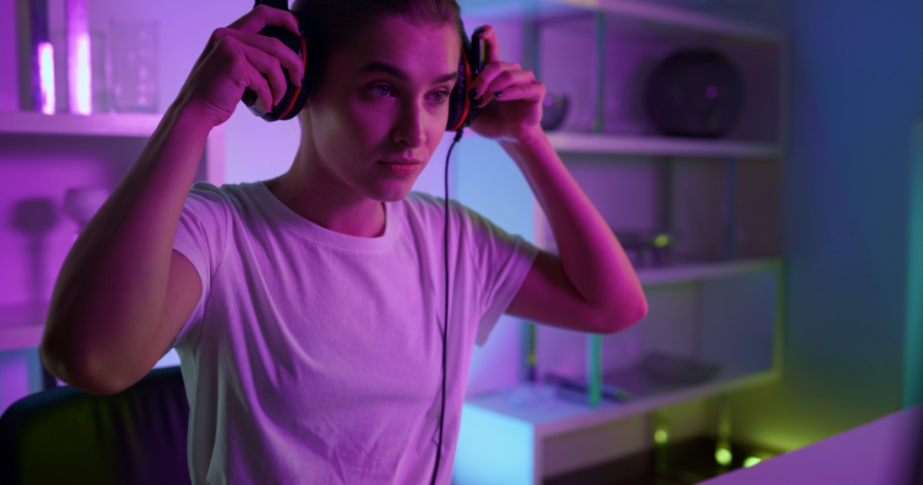 A gamer putting on noise-canceling headphones in a focused environment