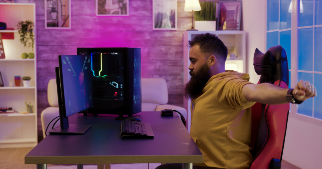 A casual player standing up, stretching while at their gaming setup
